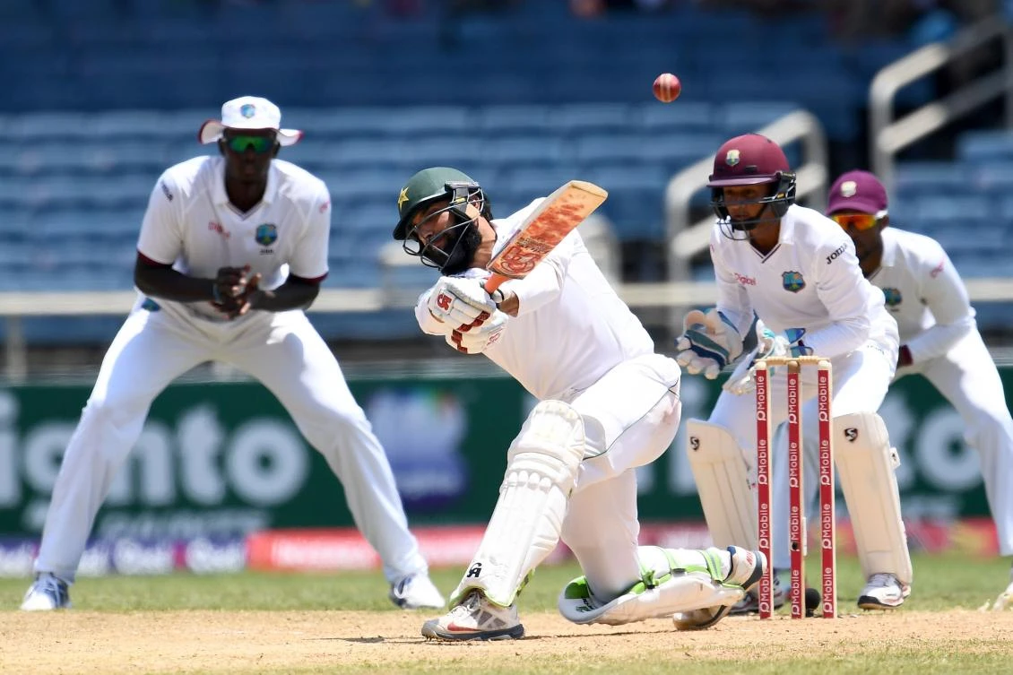 Pakistan's captain Misbah-ul-Haq hits a boundary to score the winning runs as his West Indies' counterpart Jason Holder, left, and wicketkeeper Shane Dowrich, right, watch, on the final day of the first Test match between West Indies and Pakistan at the Sabina Park in Kingston, Jamaica, on Wednesday. Pakistan defeated West Indies by 7 wickets to lead the three-Test-match series 1-0. (AFP)