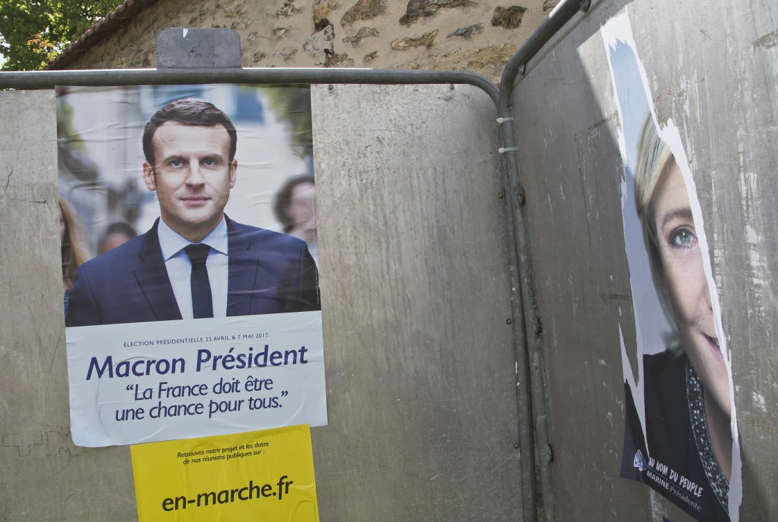 Campaign posters of Independent centrist presidential candidate Emmanuel Macron, left, and a torn down far-right presidential candidate Marine Le Pen. (AP)
