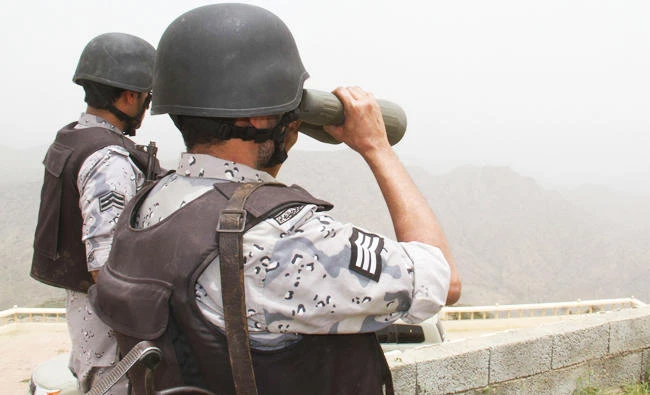 A Saudi border guard looks through binoculars at a post on the Saudi-Yemeni border, in southwestern Saudi Arabia, in this file photo. (AFP)