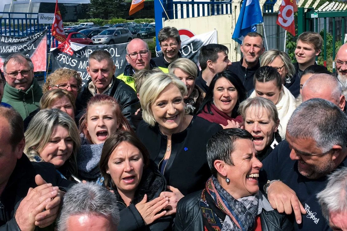 French presidential election candidate for the far-right Front National party, Marine Le Pen smiles with people in front of the Whirpool factory in Amiens, northern France,(AFP)