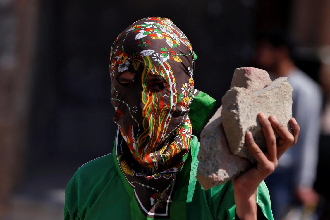 A masked protester holds stones during a protest in Srinagar, Indian-controlled Kashmir on Friday. (Reuters)