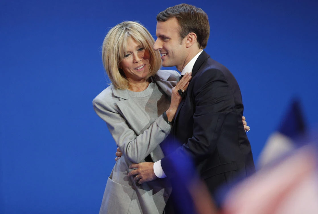 French centrist presidential candidate Emmanuel Macron and his wife Brigitte hug as he addresses his supporters at his election day headquarters in Paris , Sunday April 23, 2017. (AP)