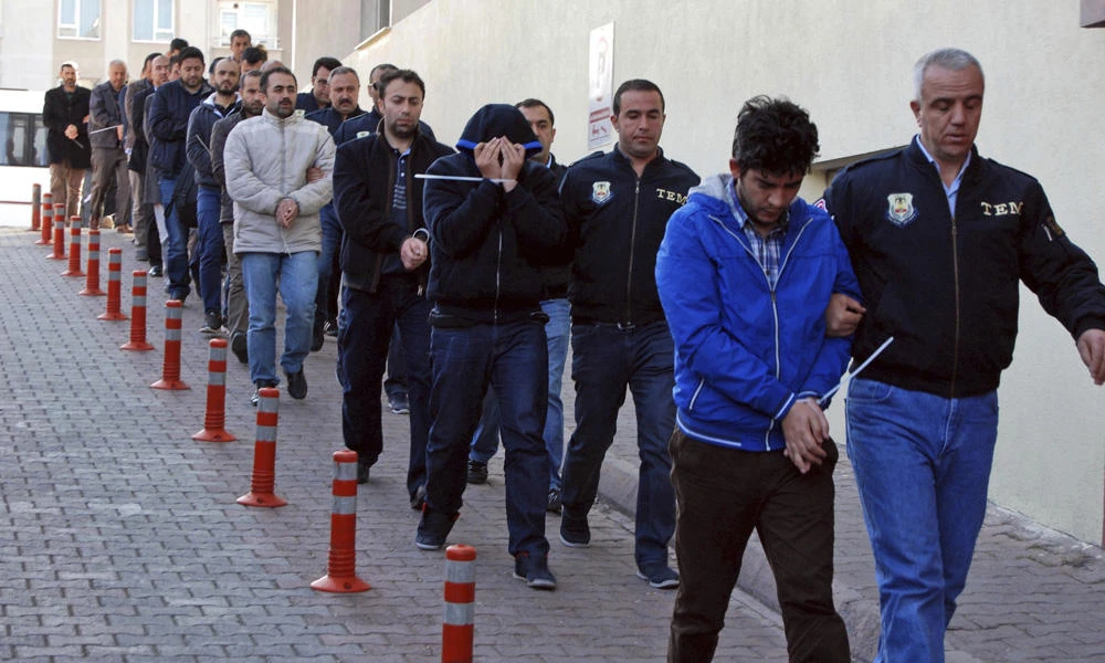 Police officers escort people, arrested because of suspected links to US-based cleric Fethullah Gulen, in Kayseri, Turkey, on April 26, 2017. Turkish authorities have expelled more than 3,900 people from the civil service, military and gendarmerie, the government said in its Official Gazette on Saturday. (Olay Duzgun/DHA-Depo Photos via AP)