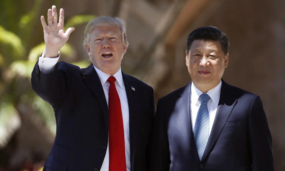 US President Donald Trump, left, and Chinese President Xi Jinping pause for photographs at Mar-a-Lago in Palm Beach, Florida, in this April 7, 2017, file photo. Trump on Sunday said China may have hacked the e-mails of Democratic officials to meddle with the 2016 presidential election, countering the view of US intelligence officials who have said Moscow orchestrated the hacks. (AP Photo/Alex Brandon, File)