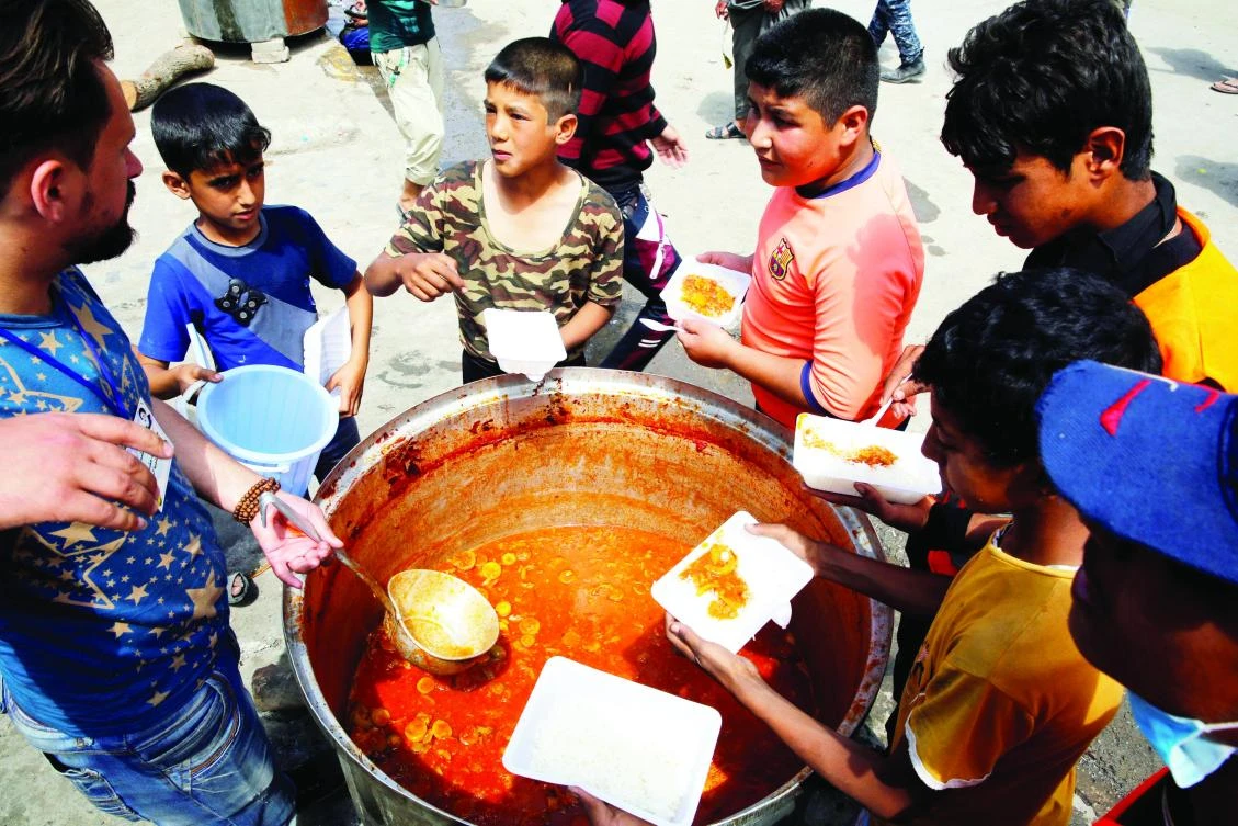 Residents receive food at a distribution point in western Mosul, Iraq. (Reuters)