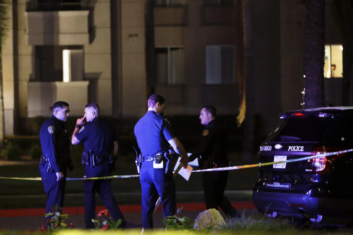 San Diego police officers stand in front of a cordoned off La Jolla apartment after a shooting Sunday, April 30, 2017, in San Diego. Police shot and killed a 49-year-old man suspected of shooting several people Sunday at a birthday pool party in an apartment complex near the University of California, San Diego, authorities said. (AP)