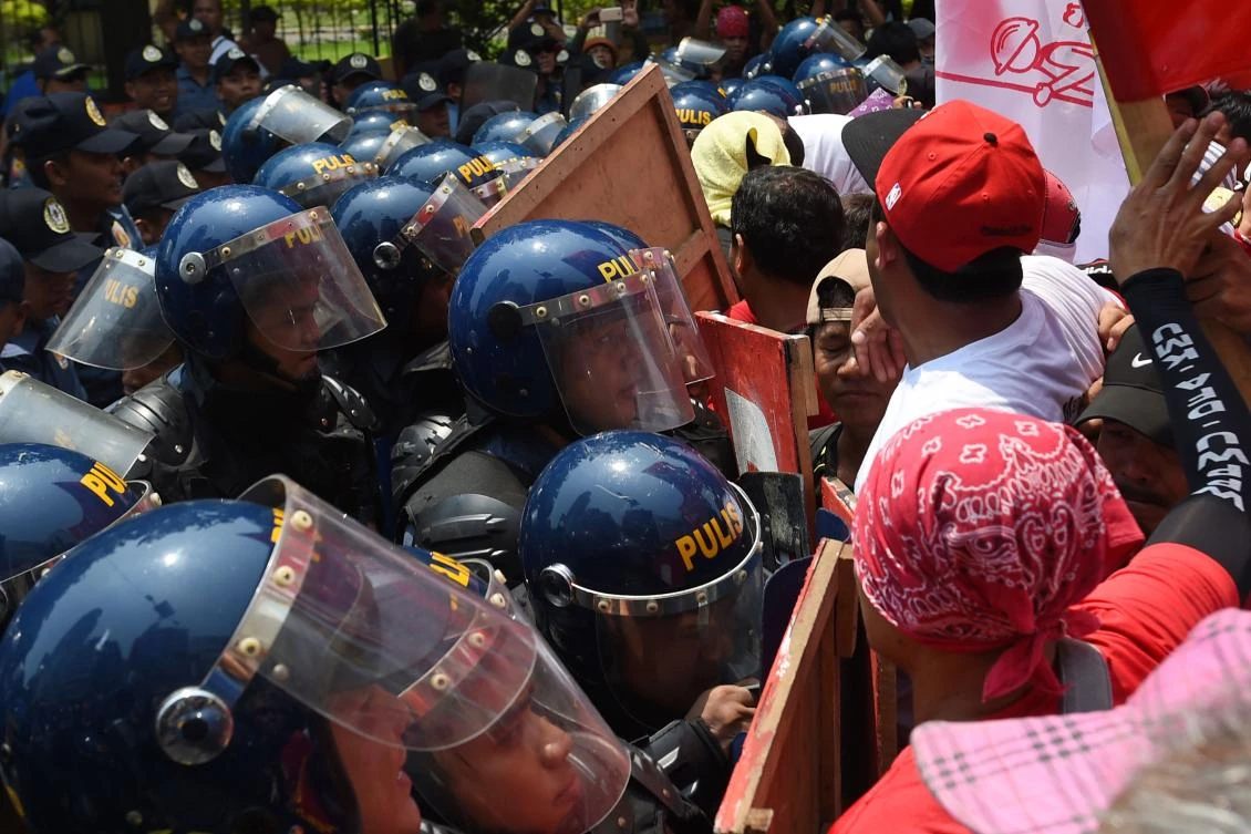 Demonstrating Philippine workers attempt to push through a column of anti-riot police as they march toward the US embassy during a May Day rally in (AFP)