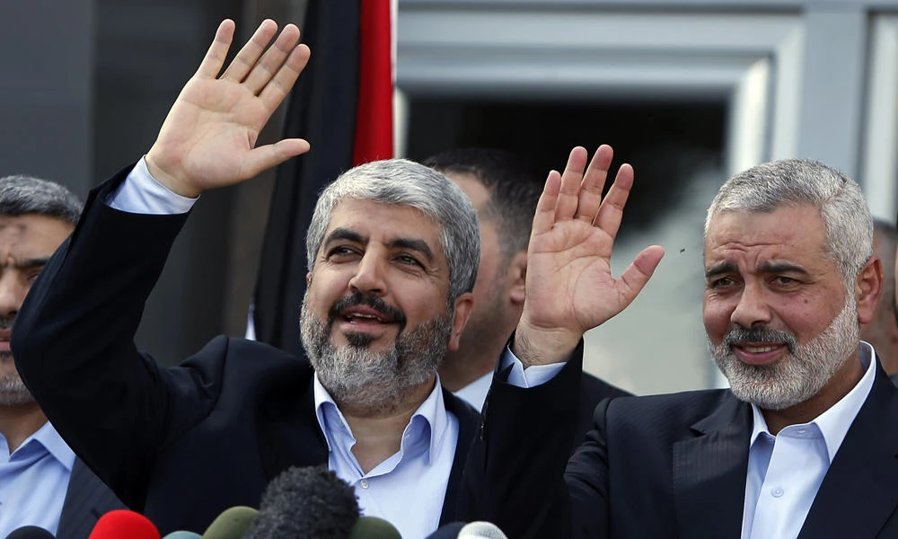 In this Dec. 7, 2012 file photo, formerly exiled Hamas chief Khaled Mashaal, left, and Gaza's Hamas Prime Minister Ismail Haniyeh wave during a news conference upon Mashaal's arrival at the Rafah crossing in the southern Gaza Strip. A new political program of Hamas, published Monday, May 1, 2017, is meant to help the Islamic militant group break out of its international isolation. (AP Photo/Suhaib Salem, Pool)