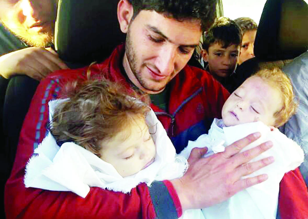 Abdul-Hamid Alyousef holds his twin babies who were killed by a chemical weapons attack in Khan Sheikhun in the northern province of Idlib, Syria, in this April 4 photo. (AP)