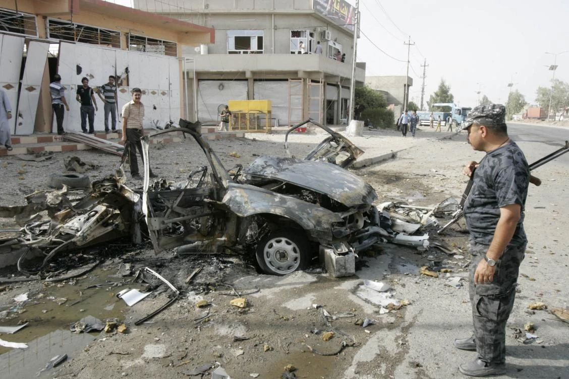 Security personnel inspect the site of a car bomb attack in Kirkuk. Gunmen killed a senior official of Iraq’s state-run North Gas Company in the city on Tuesday. (Reuters)