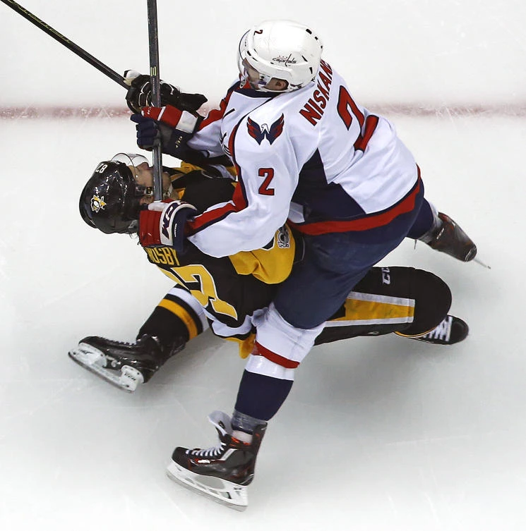Pittsburgh Penguins' Sidney Crosby takes a hit from Washington Capitals' Matt Niskanen during the first period of Game 3 in an NHL Stanley Cup Eastern Conference semifinal hockey game against the Washington Capitals in Pittsburgh Monday. Crosby left the game and did not return. The Capitals won in overtime 3-2. (AP)