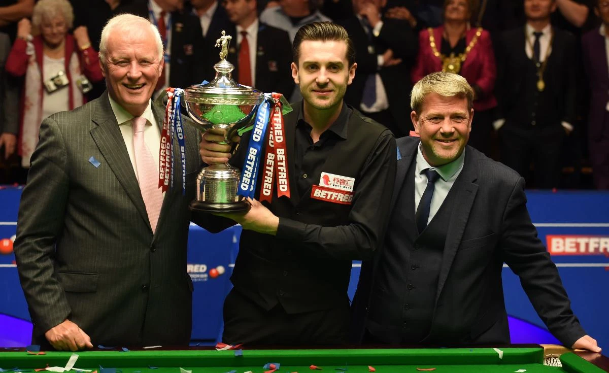 England's Mark Selby, center, with the trophy beside chairman of world snooker Barry Hearn, left, after beating Scotland's John Higgins in the World Championship Snooker final at The Crucible in Sheffield, northern England on Monday. (AFP)