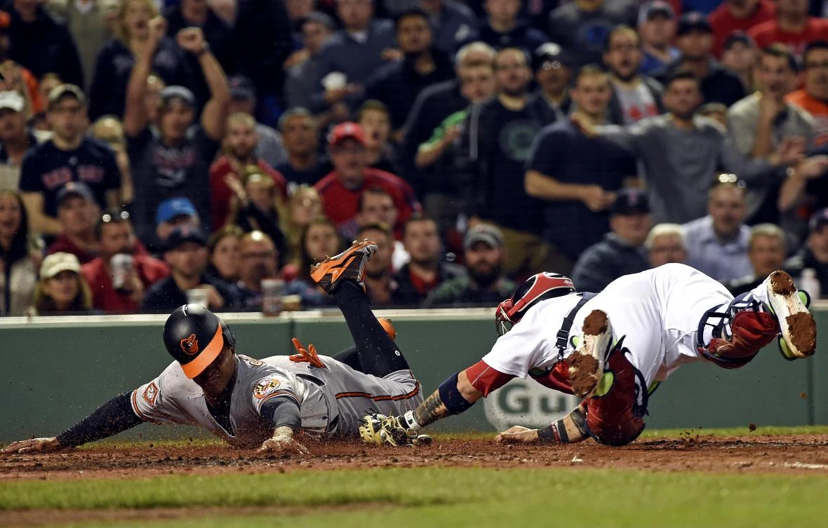 Baltimore Orioles second baseman Jonathan Schoop (6) slides safely past the tag of Boston Red Sox catcher Sandy Leon (3) during the fifth inning at Fenway Park on Tuesday night. (USA TODAY Sports)