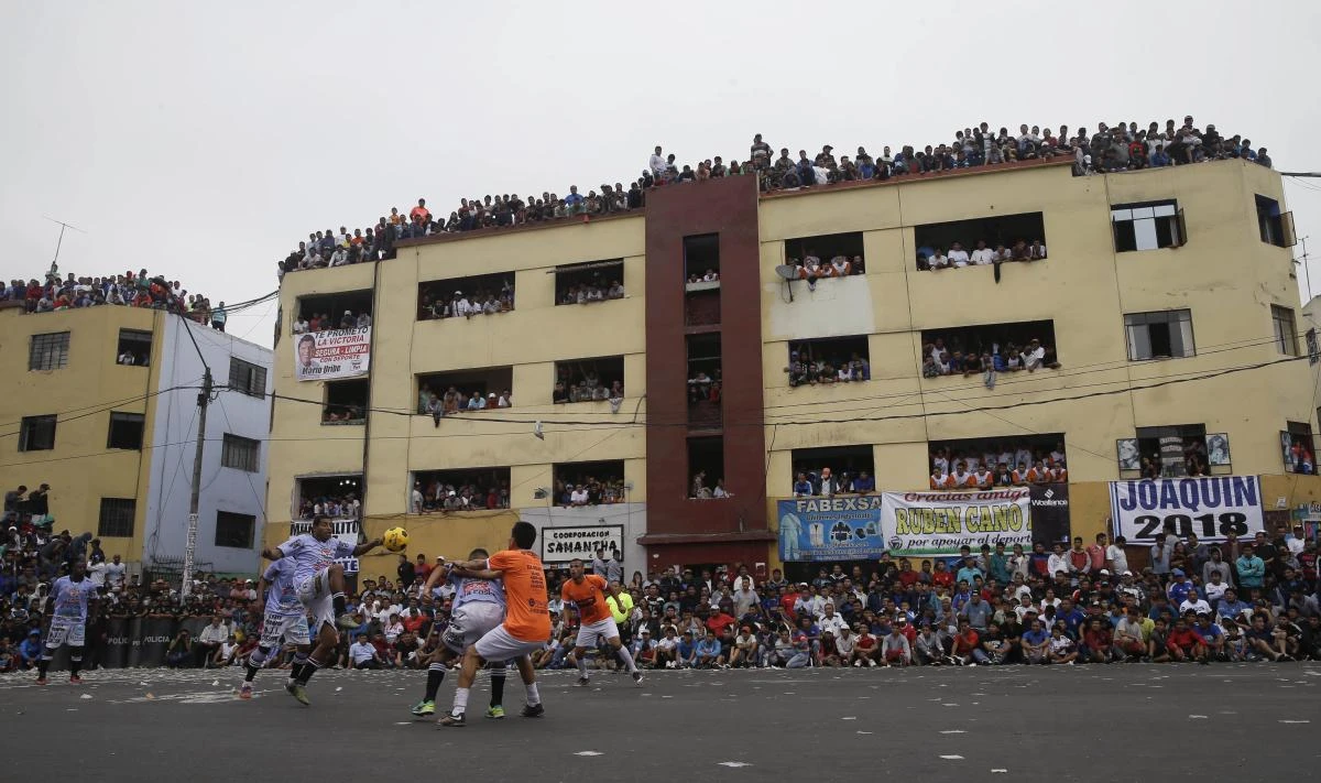 In this Monday photo, residents crowd the balconies of an apartment building to watch soccer teams "La Polvora," (Gun Powder) and "Los Chatarreros" (The Scrappers) play a semifinal game at the Little World Cup Porvenir street soccer championship in Lima, Peru. Residents pay about $2 dollars for a balcony view of the annual ritual. (AP)