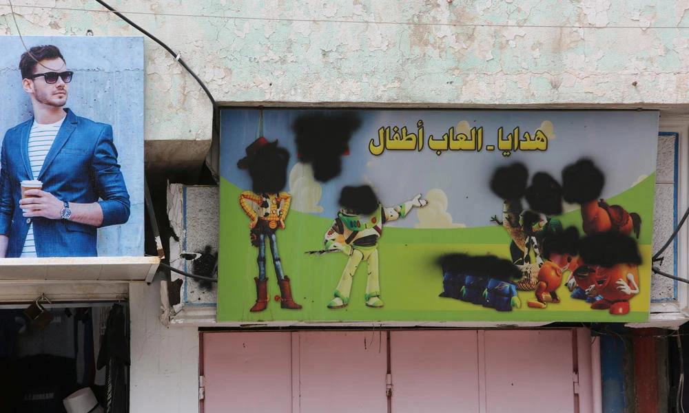 Cartoon characters defaced by Daesh militants are seen on a hoarding outside a shop in eastern Mosul, Iraq, on April 30, 2017. Tired of security crackdowns on their communications and propaganda, Daesh militants are developing their own social media platform, the head of the European Union’s police agency said on Wednesday. (REUTERS/Marius Bosch)