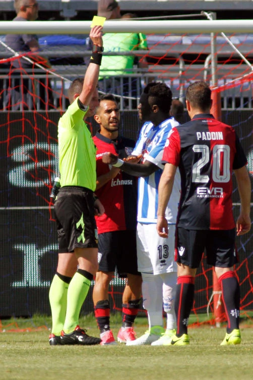 Referee Daniele Minelli shows the yellow card to Pescara’s Sulley Muntari, second from right, during a Serie A soccer match between Pescara and Cagliari, at the Cagliari Sant’Elia stadium, Italy, Sunday, April 30, 2017. (ANSA via AP)