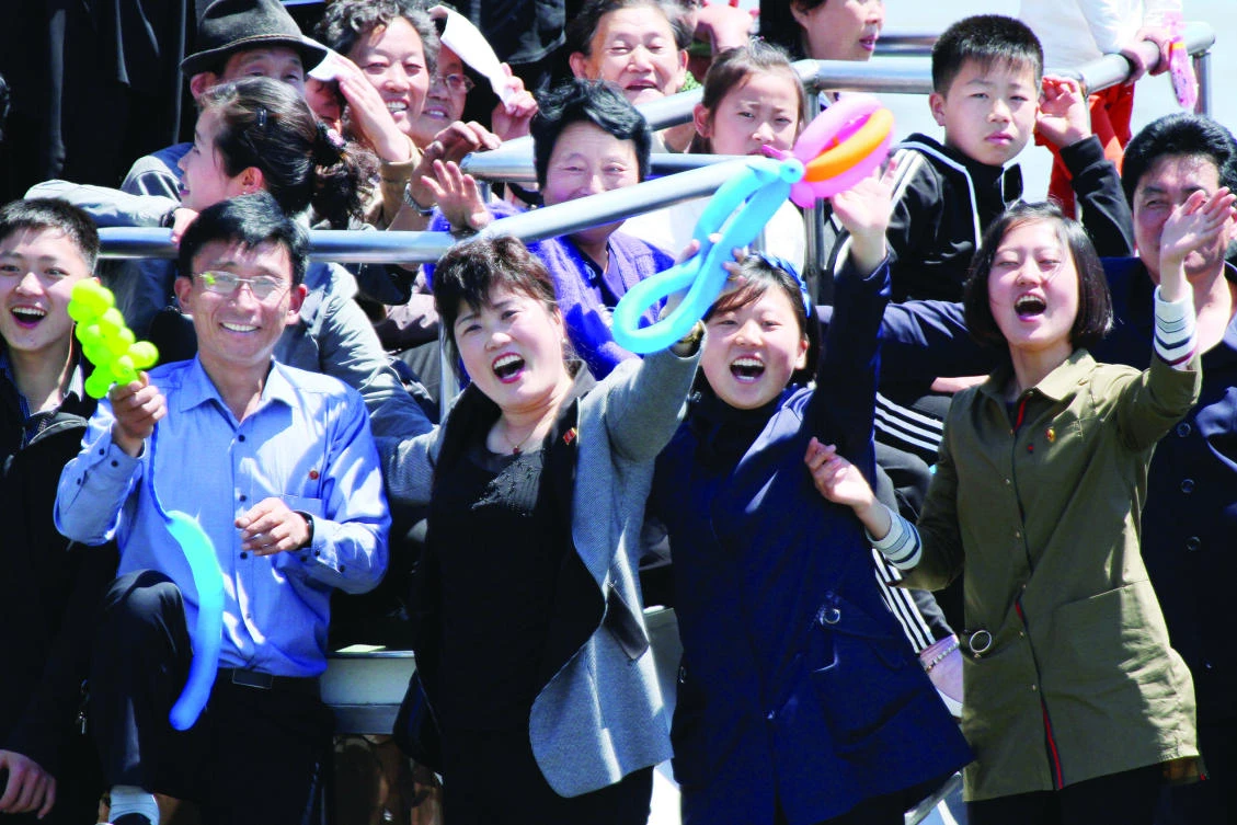North Korean people wave during a tour on a vessel on the Yalu river, in Sinuiju, North Korea, opposite the Chinese border city of Dandong, last week. (Reuters)
