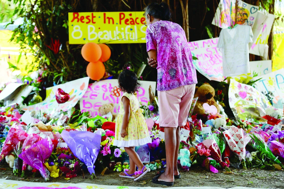 Mourners at the scene where eight children ranging from babies to teenagers were found dead in a house in the northern Australian city of Cairns in this December 2014 file photo. (AFP)