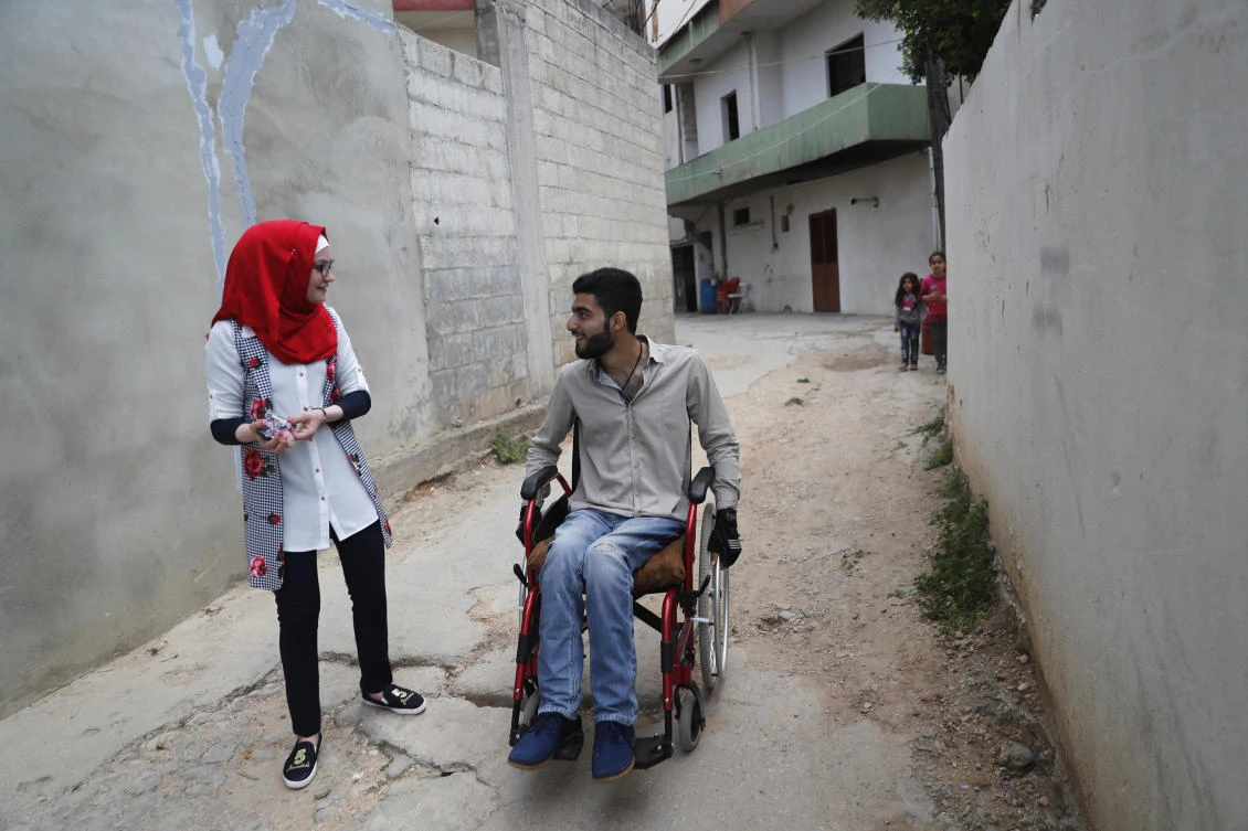 In this picture taken on Thursday, April 27, 2017, Hamida, 17, left, who was riddled with bullets and suffered a gaping hole in her back and stomach during a clash between the Syrian government forces and rebels, walks next of a Syrian man Adnan, 19, right, who also received a bullet in the spine from a sniper in Homs province, in Bebnine town, north Lebanon. Adnan, who is from the same area as Hamida and her sister Alaa in Syria, has made friends with the girls in Lebanon where they are all receiving treatment. (AP)