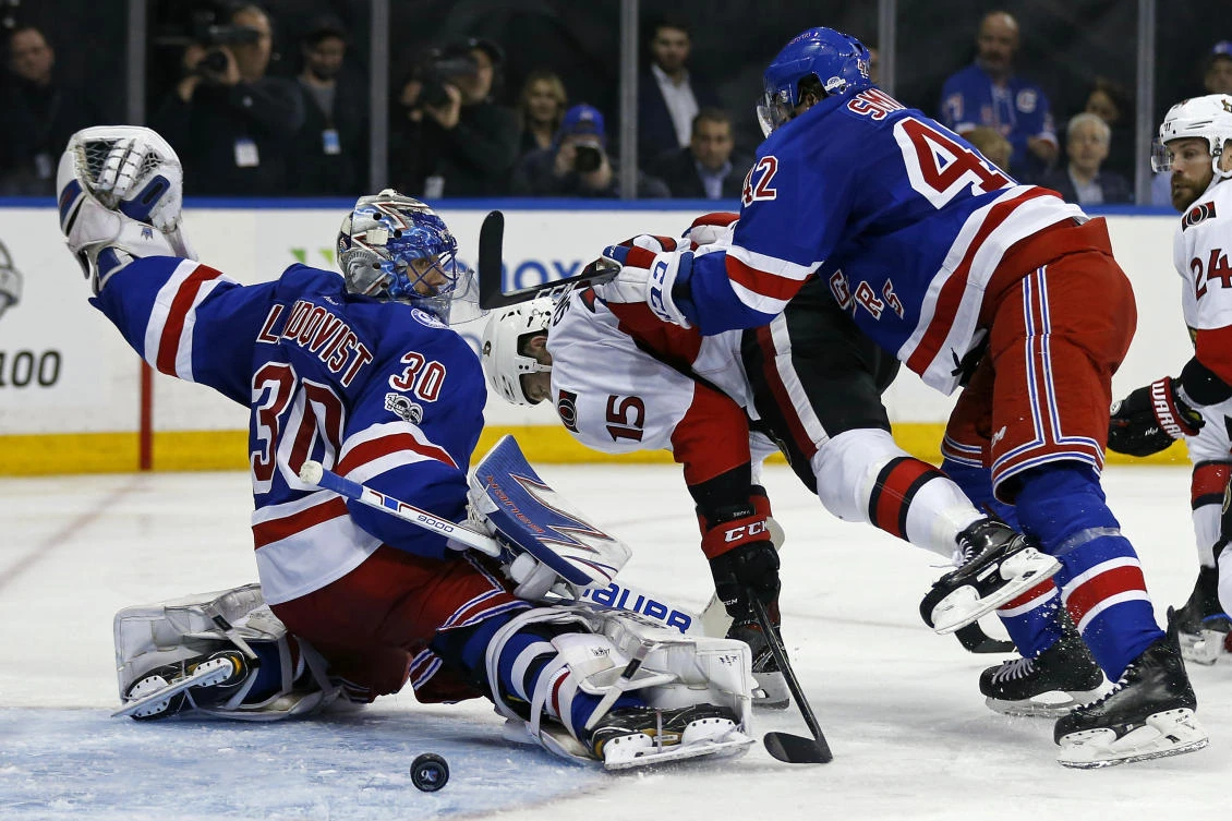 New York Rangers goalie Henrik Lundqvist (30) makes a save as New York Rangers defenseman Brendan Smith (42) checks Ottawa Senators center Zack Smith (15) during the third period in game four of the second round of the Stanley Cup Playoffs at Madison Square Garden on Thursday night. (USA TODAY Sports)