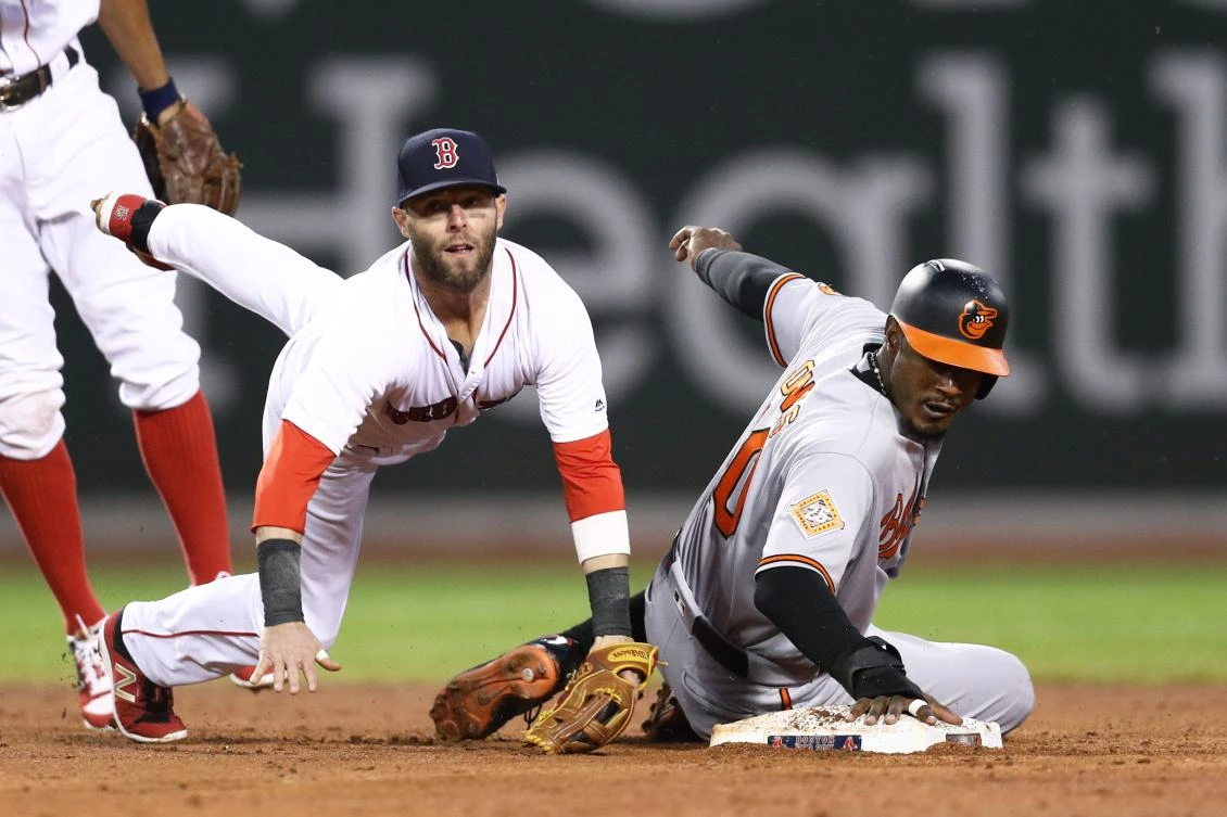 Dustin Pedroia (15) of the Boston Red Sox falls over Adam Jones (10) of the Baltimore Orioles after throwing to first during the third inning at Fenway Park in Boston, Massachusetts, on Thursday night. (AFP)