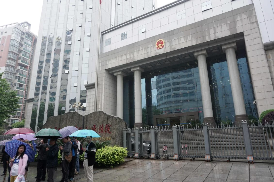 People gather outside the Intermediate People's Court in Changsha. (AFP)