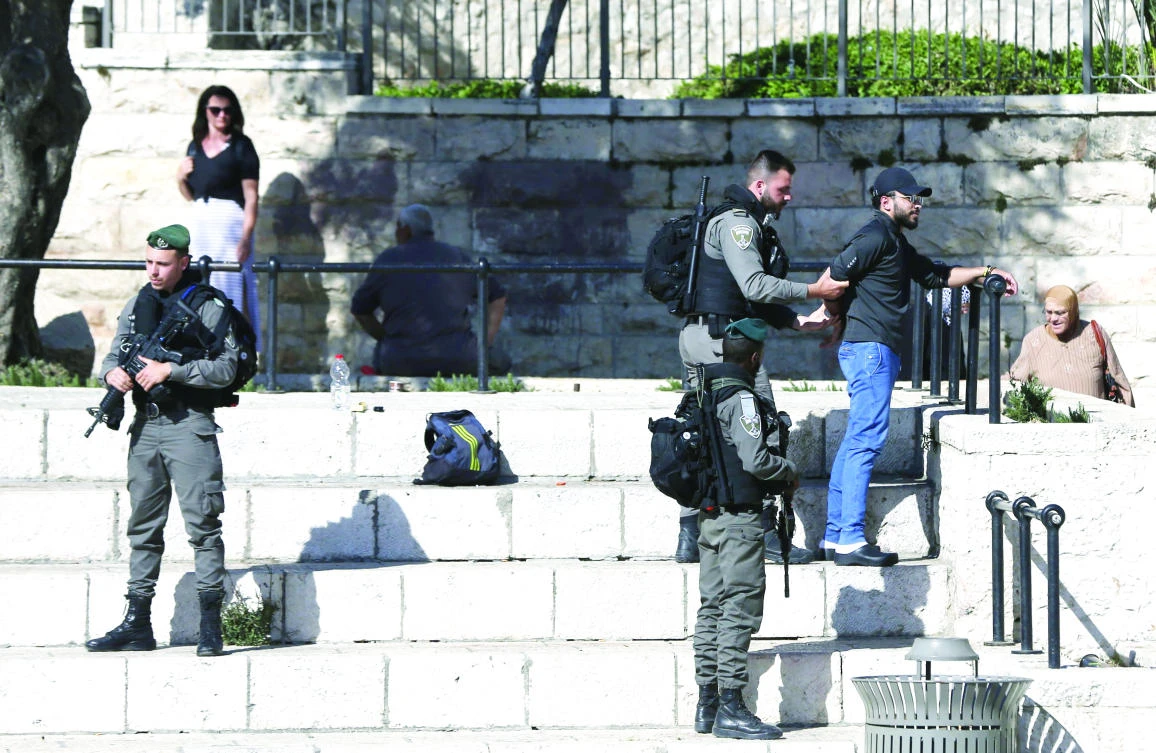 Israeli security forces frisk a Palestinian in Jerusalem’s Old City on April 29. (AFP)