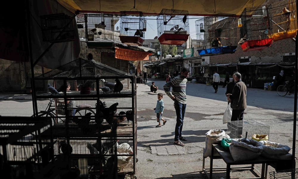 A Syrian man sells birds on the street in the rebel-held town of Douma, on the eastern outskirts of Damascus on Saturday. Fighting subsided in Syria after a deal signed by government backers Russia and Iran and rebel supporter Turkey to create four safe zones began to take effect, a monitor said. (AFP / Sameer Al-Doumy)
