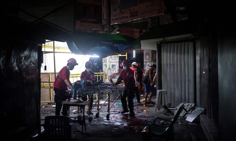 Rescue workers attend to a wounded man on a stretcher in an alley in Manila's old district of Quiapo on April 28, 2017, after a homemade pipe bomb exploded. On Saturday, two explosions in the same place on Saturday night killed at least two people and injured four others, police and witnesses said. (AFP file photo)