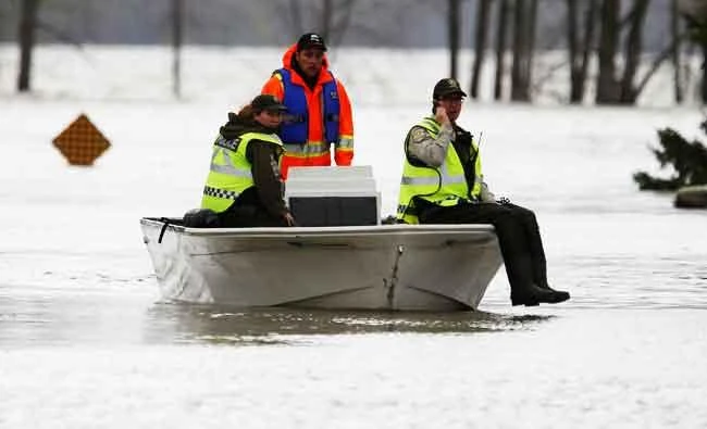 Police ride on a boat in a flooded residential area in Rigaud, Quebec, Canada, on Saturday. (REUTERS)
