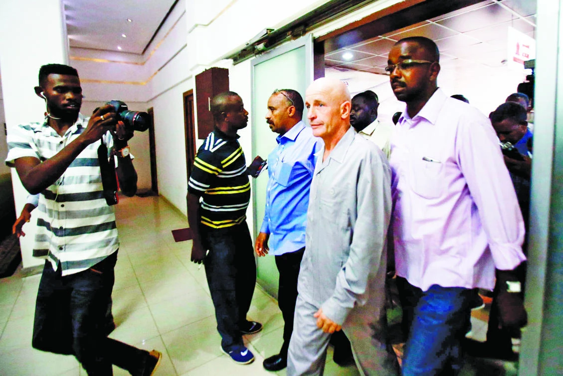 Thierry Frezier, second right, arrives at Khartoum Airport on Sunday, upon being freed after more than six weeks in captivity. (AFP)