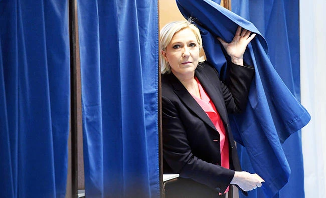 French presidential election candidate for the far-right Front National (FN - National Front) party Marine Le Pen walks out a polling booth at a polling station in Henin-Beaumont, north-western France, on Sunday, during the second round of the French presidential election. (AFP)