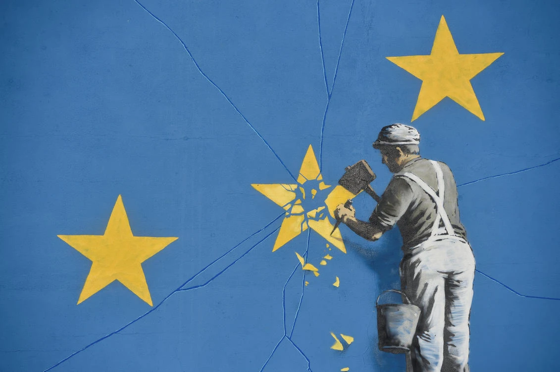 A section of an artwork attributed to street artist Banksy, depicting a workman chipping away at one of the 12 stars on the flag of the European Union, is seen on a wall in the ferry port of Dover, Britain May 7, 2017. (Reuters)