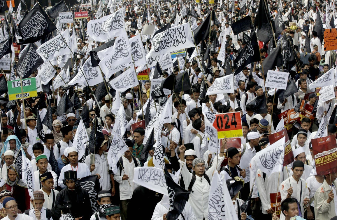 FILE - In this Saturday, May 30, 2015 file photo, members of Hizbut Tahrir Indonesia wave flags during a rally calling for the creation of Islamic caliphate and the implementation of Sharia law in Jakarta. Indonesia's top Security Minister Wiranto, who goes by one name, said Monday, May 8, 2017, the government will take legal measures to dissolve the hard-line Islamic group that favors a global caliphate for Muslim nations. (AP)