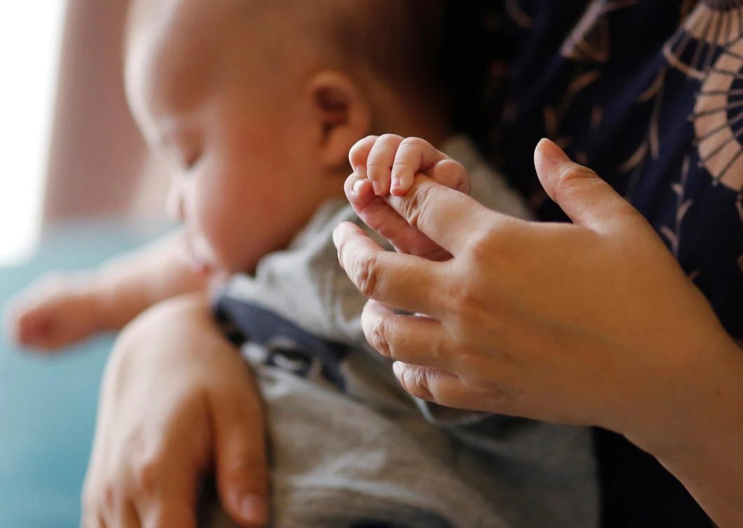 Asako Yoshinari and her 2-month-old foster son are pictured at home in Inzai, Chiba Prefecture, on Friday. (REUTERS)