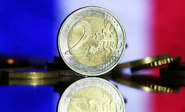 Euro coins are seen in front of displayed France flag in this photo illustration taken on May 7, 2017. (REUTERS)