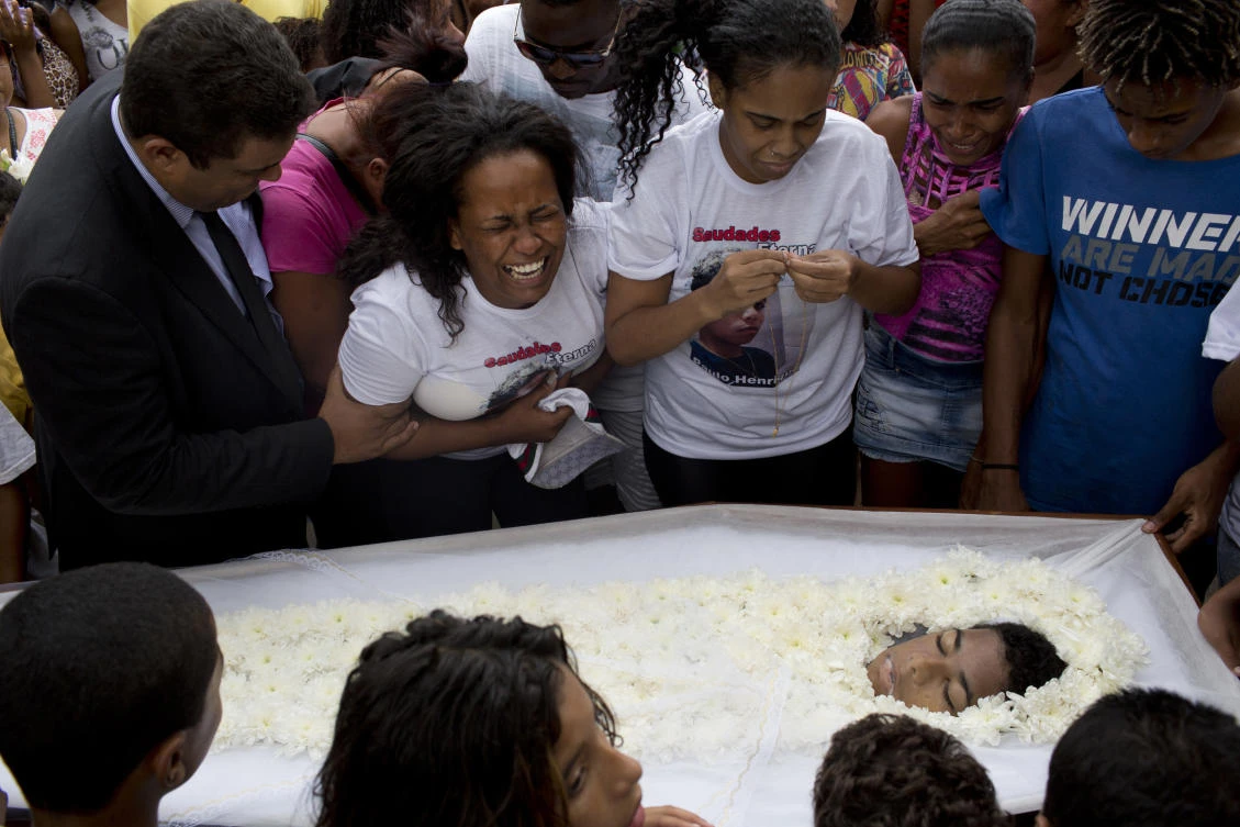 A woman cries during the burial of her son. (AP)