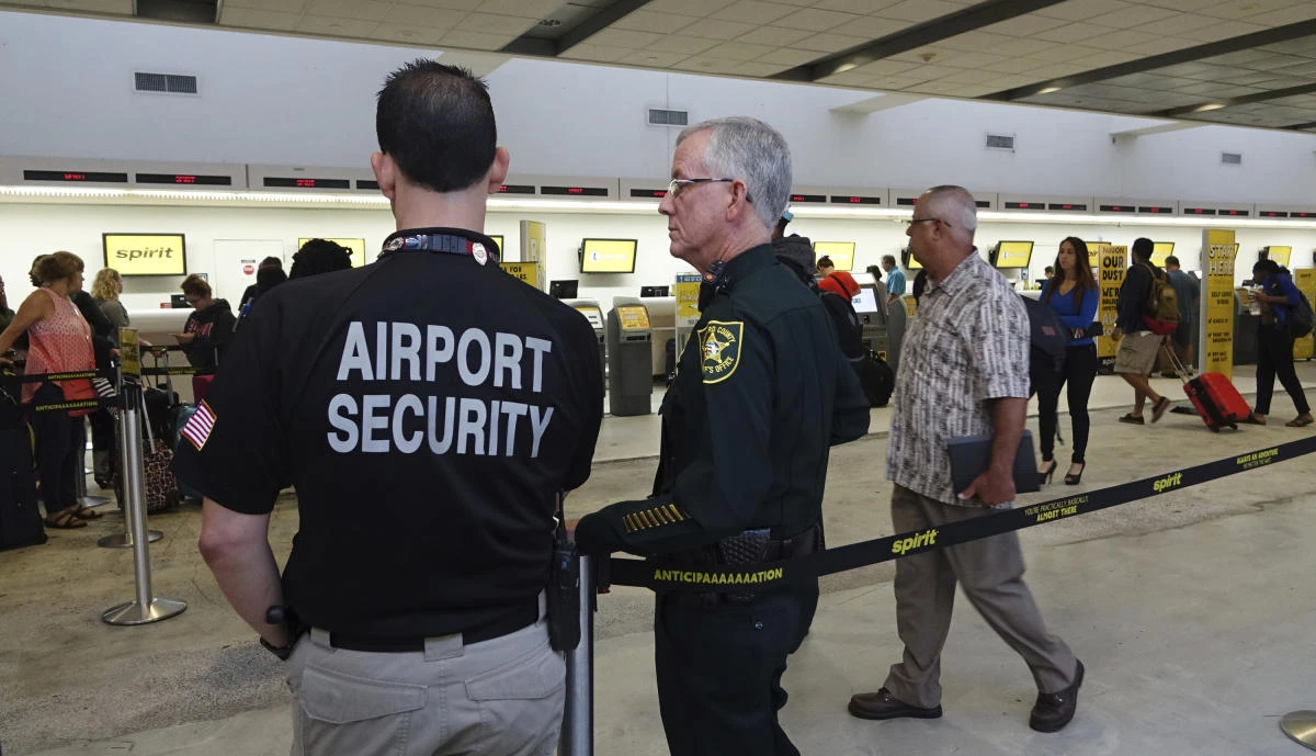 Airport Security and a Broward Sherriff's Deputy keep an eye on the line at Spirit Airlines on Tuesday at the Fort Lauderdale-Hollywood International Airport in Fort Lauderdale, Florida. (Joe Cavaretta/South Florida Sun-Sentinel via AP)