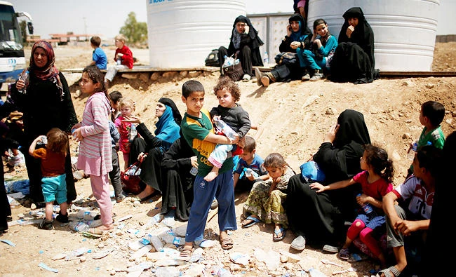 Displaced Iraqis wait to move to a safe place as Iraqi forces battle with Daesh militants, in western Mosul, Iraq on Wednesday. (REUTERS)