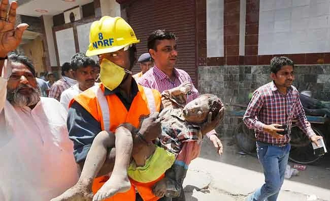 This April 22, 2015 file photo shows, a members of National Disaster Response Force carries an injured child, found under the debris of a residential building, to an ambulance, in New Delhi, India. (AP)