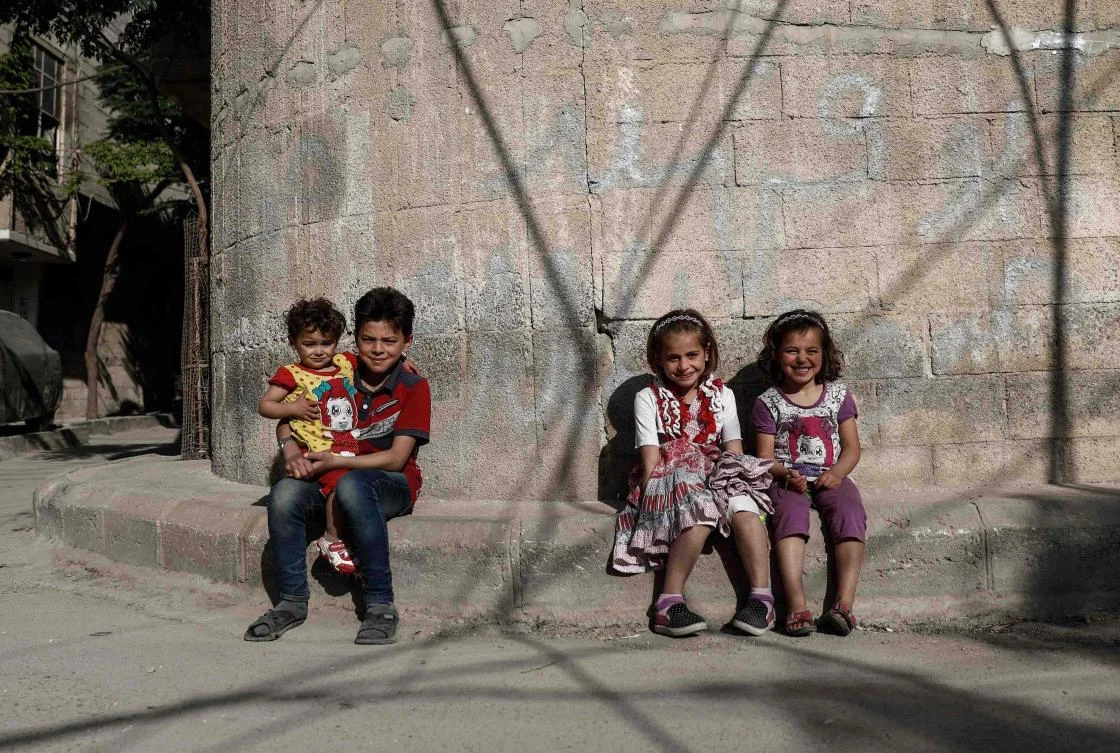 Syrian children pose for a photo near their house in the rebel-held town of Douma, on the eastern outskirts of Damascus. (AFP)
