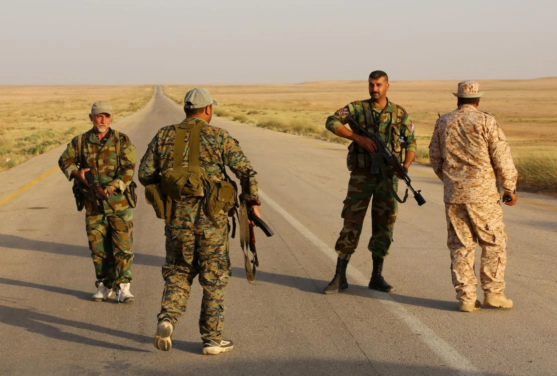 Syrian regime forces secure a road for a military convoy in the desert area of Saba' Biyar, in southeastern Syria. (AFP)