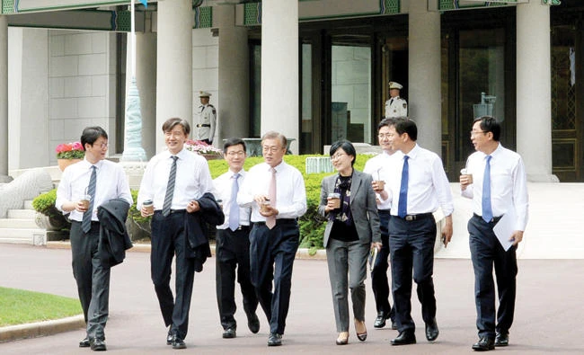 South Korean President Moon Jae-in talks with senior presidential secretaries as they take a walk at the Presidential Blue House in Seoul on Thursday. (Reuters)
