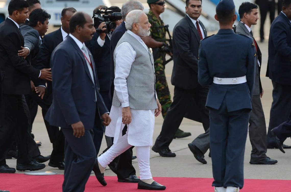 India's Prime Minister Narendra Modi (C) walks with officials after arriving at Bandaranaike International Airport in Colombo. (AFP)