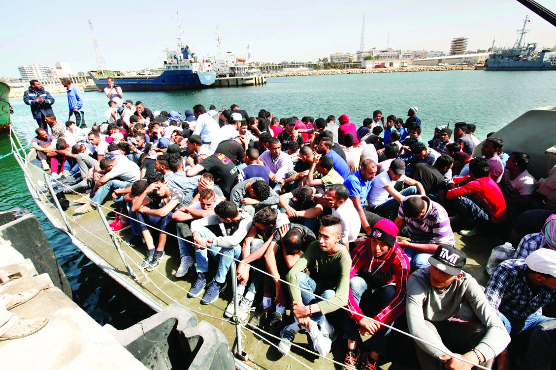 Illegal migrants arrive by boat at a naval base after they were rescued by Libyan coast guard in the coastal city of Tripoli on Wednesday. (Reuters)