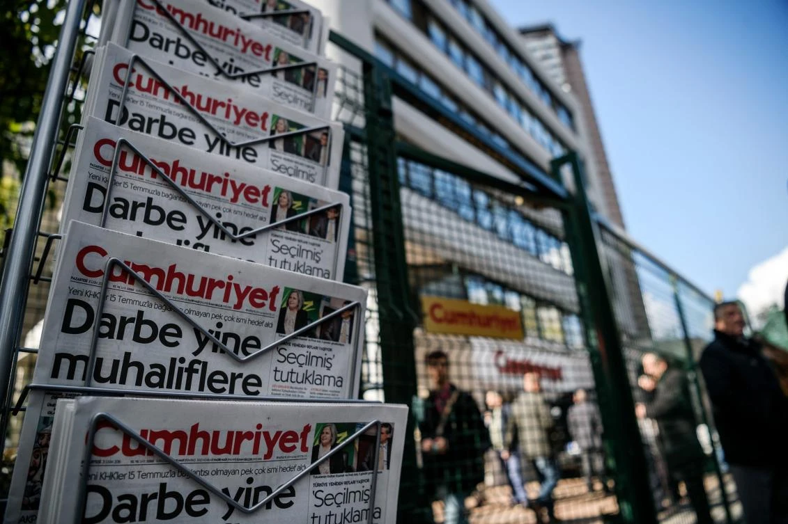 People standing next to copies of Cumhuriyet daily newspaper in front of the newspaper's headquarters in Istanbul. (AFP)