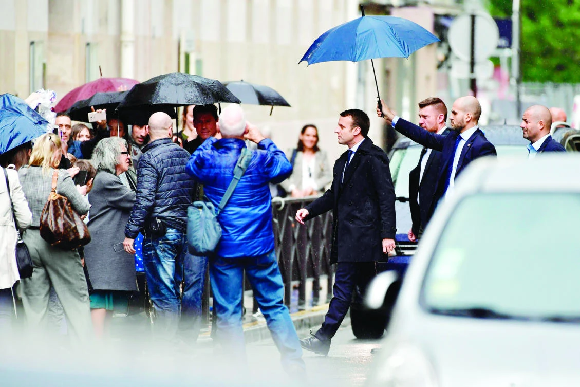 France's President-elect Emmanuel Macron walks in a street, on Thursday in Paris. (AFP)
