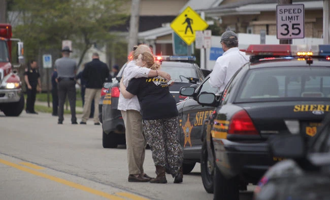 People hug as emergency personnel arrive to the scene of a shooting outside Pine Kirk nursing home in Kirkersville, Ohio on Friday. (Tom Dodge/The Columbus Dispatch via AP)
