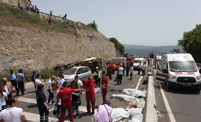 Medics and rescue workers stand at the scene after a tourist bus crashed near the southwestern holiday town of Marmaris, Turkey, on Saturday. (REUTERS/Kenan Gurbuz)