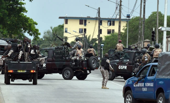 Ivorian soldiers and gendarmes patrol in their vehicle by Ivory Coast's army headquarters, the Gallieni military camp, in Abidjan on May 12, 2017 as they fired shots in the air just hours after a spokesman for the protesters publicly apologized for an earlier mutiny. (AFP / ISSOUF SANOGO)